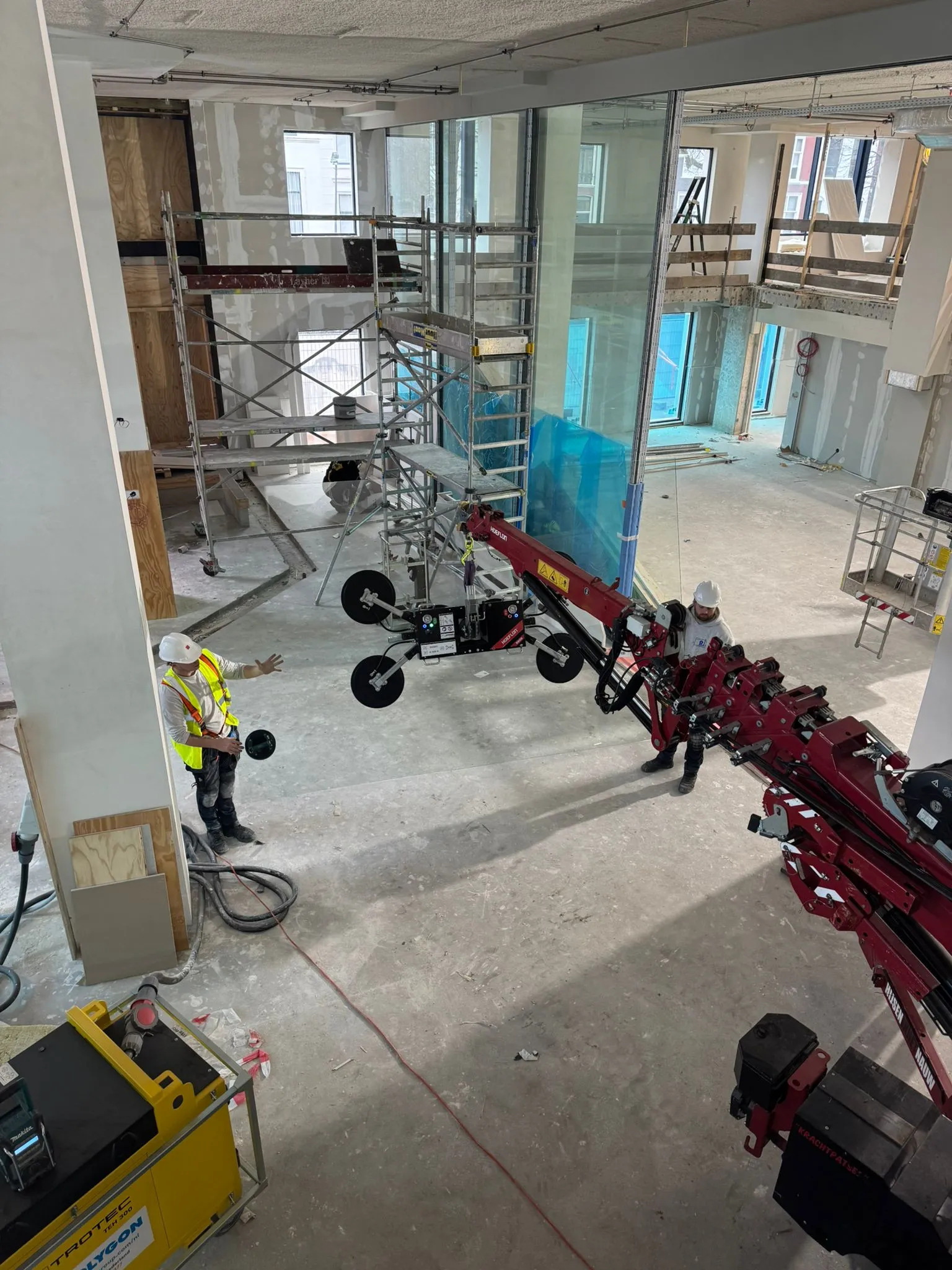 Bovenaanzicht bouwplaats waar Rotec kraanarm ruit naar binnen steekt voor montage