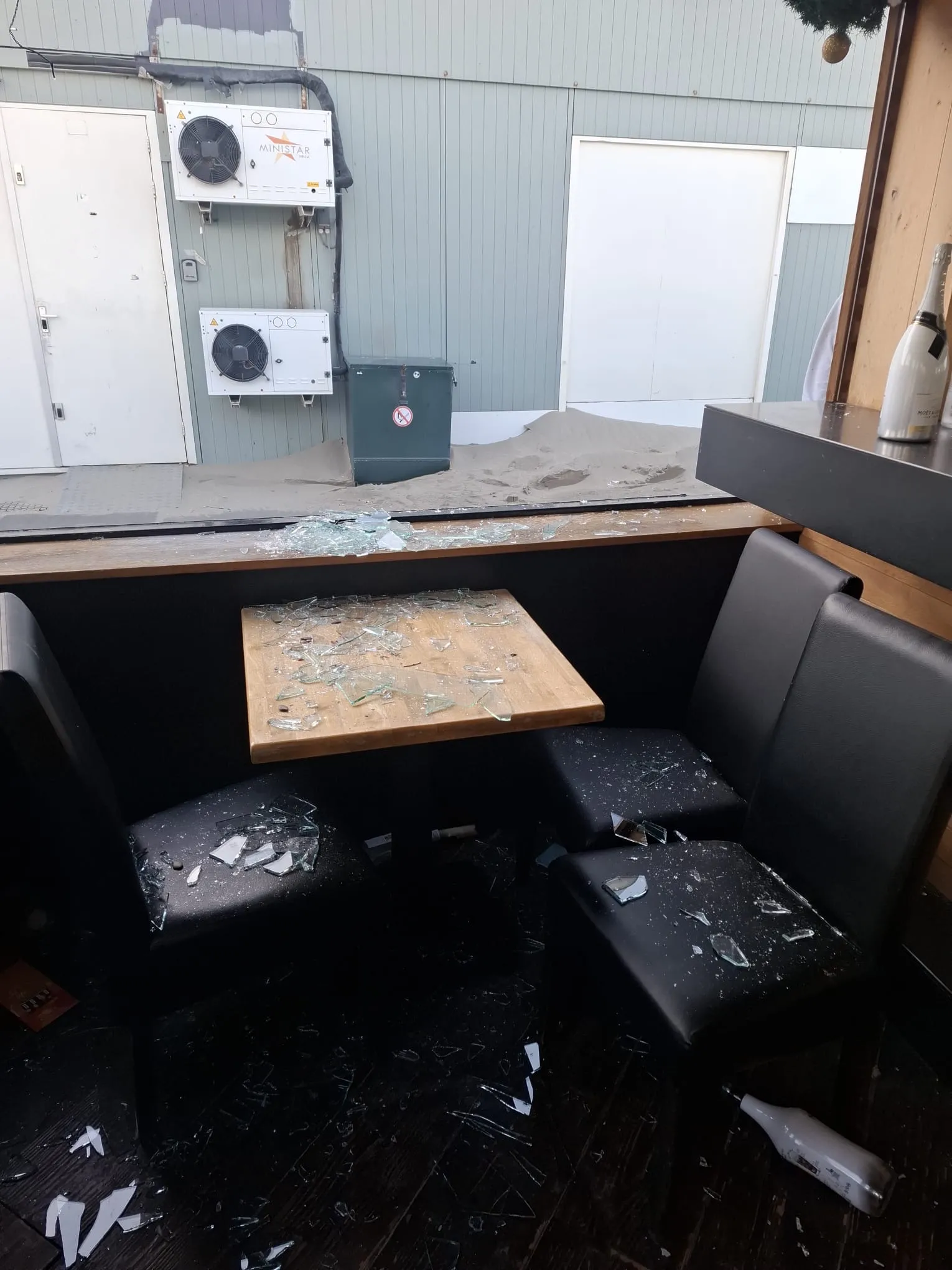 Versplinterd glas op tafel en stoelen in horecagelegenheid - glasschade spoedservice